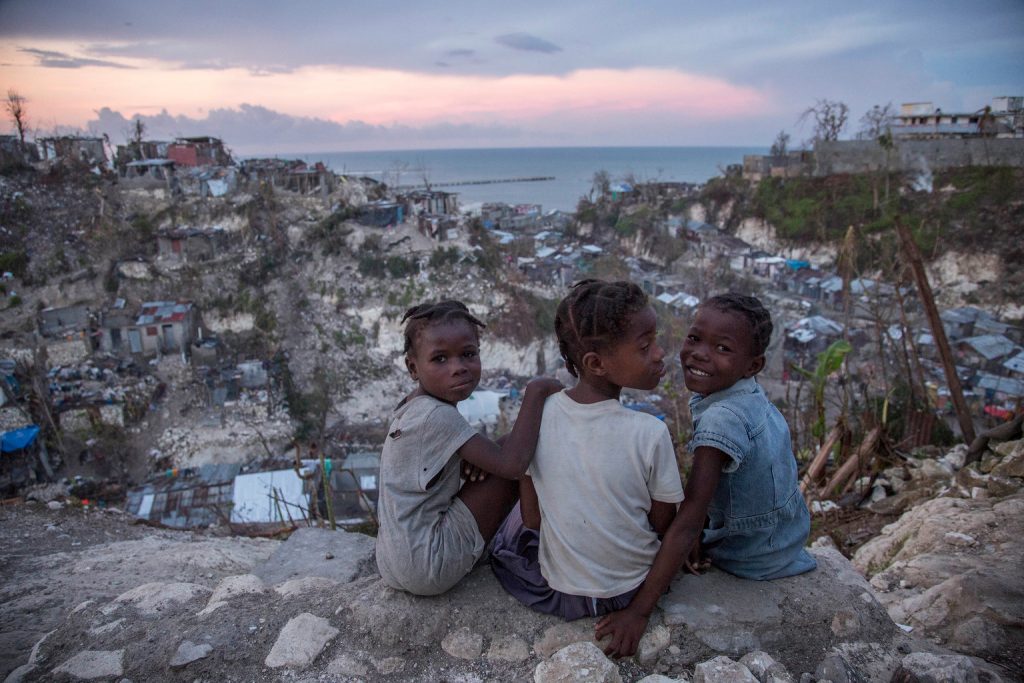 On 13 October 2016 in Jérémie, Haiti, (right) Mylove Théogène, 8, sits with other girls near her home. Myloves family stayed in their home on a hilltop until their home collapsed around 5:00am on the night Hurricane Matthew struck Haiti. Then, the family then moved to a school house for shelter. "I thought I was going to die. I thought my family would all die" said Mylove. The family of five lost their father in February 2016, when he fell from a tree while collecting fruit for the family to eat. "When I grow up I want to go to school" Mylove remarks as a second-grader who has not been to school at all in 2016. More than one week after Hurricane Matthew, as schools re-open across the country, more than 100,000 children will be missing out on learning after their schools were either damaged or converted into shelters.
Hurricane Matthew passed over Haiti on Tuesday October 4, 2016, with heavy rains and winds. While the capital Port au Prince was mostly spared from the full strength of the class 4 hurricane, the western area of Grand Anse, however was in the direct path. The cities of Les Cayes and Jeremie received the full force sustaining wind and water damage across wide areas. Coastal towns were severely damaged as were many homes in remote mountainous regions. International relief efforts are underway to provide food water and shelter to the people affected by the storm.
An estimated 500,000 children live in the Grande Anse Department and Grand South Department in southern Haiti, the areas worst hit by Hurricane Matthew. UNICEF had prepositioned emergency supplies with national authorities to reach up to 10,000 people. On 8 October, six water trucks arrived in Jeremie and Les Cayes, the respective capital cities within the Departments. Additional water and sanitation supplies, such as water purification tablets, water bladders and plastic sheeting, have been dispatched to the most affected departments in the westernmost tip of Haiti. As of 10 Oct UNICEF/UN038071/LeMoyne
