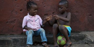 On 19 September, a boy and a girl play together while sitting on the edge of a street in Freetown, the capital.
From 1921 September in Sierra Leone, a public information campaign aimed to reach every household countrywide with life-saving messages on Ebola virus disease (EVD). UNICEF provided technical and financial support, including information materials, for the Government-led campaign, called the Ose to Ose Ebola Tok initiative, which means house-to-house talk in the local Sierra Leonean language. During the campaign, over 28,500 trained social mobilizers, youths and volunteers went door-to-door to reach 1.5 million households and provide residents with information on protecting themselves against EVD and preventing its spread. UNICEF estimates that 8.5 million children and young people under the age of 20 live in areas affected by EVD in Guinea, Liberia and Sierra Leone, countries where disease transmission is widespread and intense. Of these, 2.5 million are under the age of 5. Nigeria and Senegal are also affected, having seen an initial case or cases, or experienced localized transmission. The current EVD outbreak in West Africa is the worst in history. UNICEF/UNI171295/Bindra