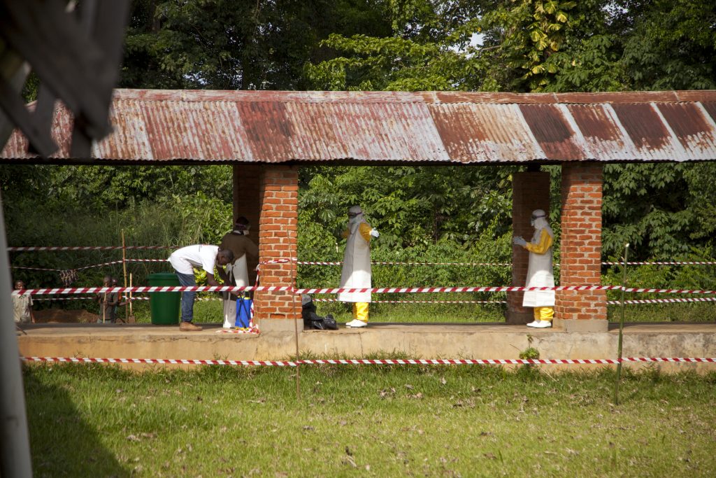 On 12 May 2018 in Democratic Republic of Congo (DRC), health workers are sprayed with chlorine after leaving the isolation ward at Bikoro Hospital, the epicenter of the latest outbreak in the DRC. Bikoro hospital has sealed off a ward to diagnose suspected Ebola patients and provide treatment. The DRC has experienced nine known Ebola outbreaks.
Following the announcement by the Government of the Democratic Republic of the Congo (DRC) on 8 May 2018 of a new Ebola outbreak in Equateur Province, UNICEF has mobilised its teams to help contain the spread of the disease. The outbreak was declared in the Bikoro Health Zone, located more than 100 kilometers south of the provincial capital of Mbandaka. A UNICEF team with two doctors, a specialist in water, sanitation and hygiene as well as a specialist in community communication left today from Mbandaka to assess the extent of the epidemic and begin implementing the response, alongside the Government and the World Health Organization (WHO). This is the ninth Ebola outbreak in the country since 1976. UNICEF supports the Government in its coordination of the response both from the country’s capital Kinshasa as well as in the affected area. UNICEF has been active in the Equateur Province for many years. Based on its experience in previous Ebola epidemics, UNICEF is focusing its response on communication activities in the communities to protect people from the disease and on water supply, hygiene and sanitation to prevent the spread of the disease. UNICEF has already sent a total of 45 kg of chlorine, five sprays, 50kg of soap and 28,000 water purification tablets to the area, as well as 600 posters and 6,000 leaflets to educate affected communities. © UNICEF/UN0209050/Naftalin