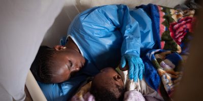 On 6 December 2018, at a UNICEF supported crèche in Beni, in the eastern DRC, Kavira Langa Jemima, an Ebola survivor, puts 6 month old Josue to bed. UN0264159/UNICEF