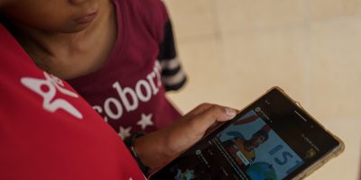 24 juillet 2020 – Phnom Penh (Cambodge). Nha Nha regarde une vidéo d'exercices d'entraînement réalisée par l'ISF avec sa petite sœur Sopheap. L'école utilise des applications de streaming pour offrir une interaction essentielle entre enseignant et élève et créer une série d'exercices d'entraînement physique. L'utilisation de Google Class, des groupes Telegram et Facebook, ainsi que de Messenger, permet aux étudiants de continuer à étudier depuis la sécurité de leur domicile. Afin de garantir que les étudiants disposent du matériel adapté pour apprendre en ligne, l’ISF prête des tablettes à ceux qui en ont besoin. Des subventions sont également disponibles pour les étudiants qui ont du mal à se permettre un service Internet. © Thomas Cristofoletti / UNICEF UNICEF/UNI358629