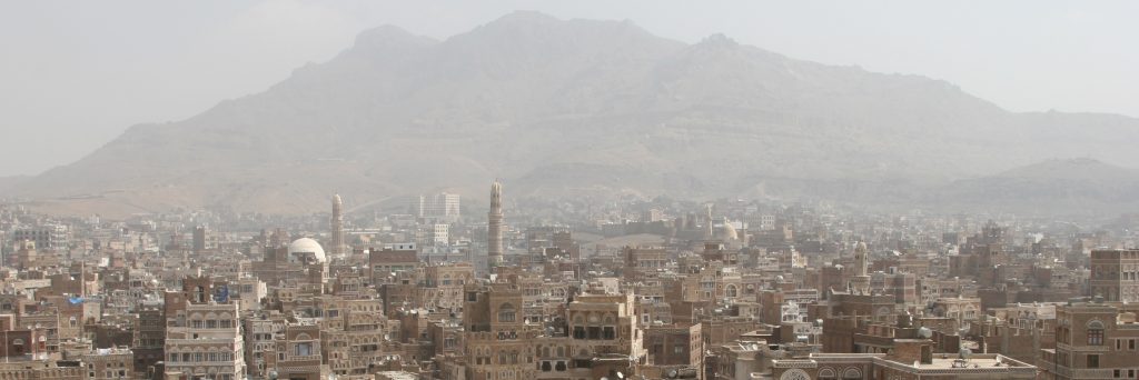 أفق مدينة صنعاء القديمة، وهي أحد مواقع التراث العالمي لليونسكو، مع الجبال المحيطة بها في الخلفية.
