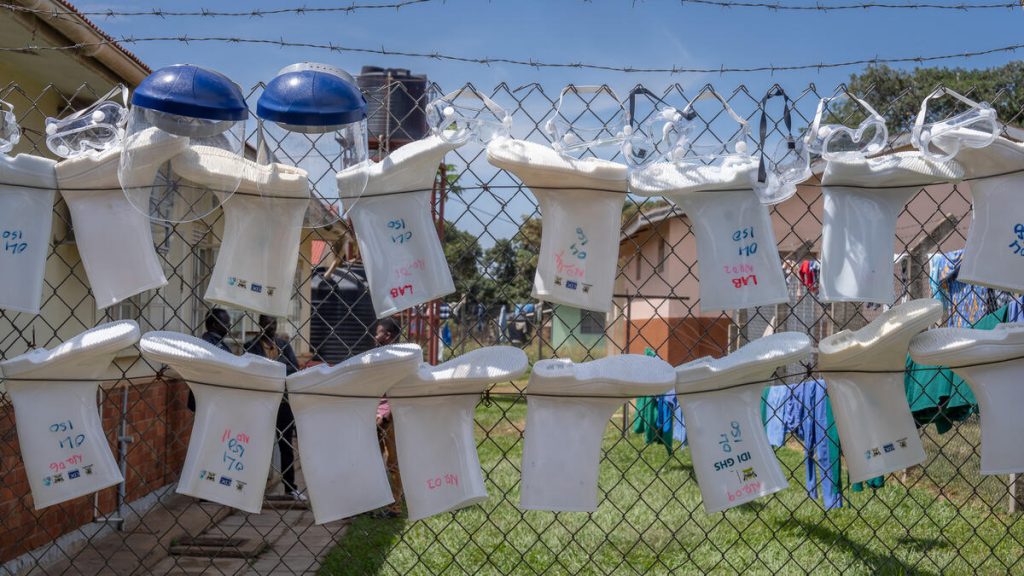 Members of Uganda's Emergency Medical Team attend to contacts of Ebola cases at Oil Health Centre 4's 12-bed isolation unit in Arua, northern Uganda, 25 June 2026. Personal protective equipment, including face shields, goggles and protective boots, hangs on a fence outside an isolation unit at Oil Health Centre IV in Arua, northern Uganda.