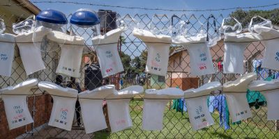 Personal protective equipment, including face shields, goggles and protective boots, hangs on a fence outside an isolation unit at Oil Health Centre IV in Arua, northern Uganda.